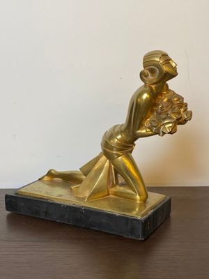 a statue of a woman holding a basket of flowers on a table