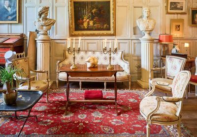 un salon avec beaucoup de meubles et des tableaux accrochés aux murs
