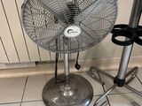 a fan sitting on the floor next to a chair