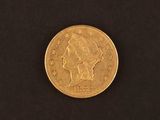 a close up of a gold coin on a black surface