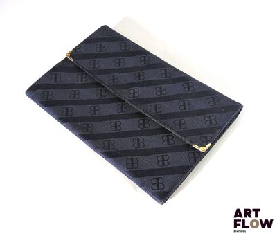 une image représentant une pochette noire et bleue posée sur une surface blanche