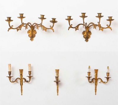 trois appliques murales en laiton fixées à un mur blanc