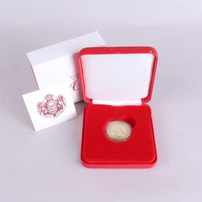 une petite boîte rouge contenant une pièce d'or