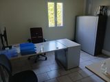 un bureau avec une chaise et un réfrigérateur dans la chambre