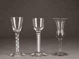 three clear wine glasses sitting on top of a table next to each other