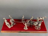 a silver model of a horse drawn carriage on a red tray