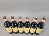 six bottles of red wine lined up in a row
