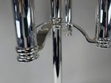 three chrome candles that are on a metal stand