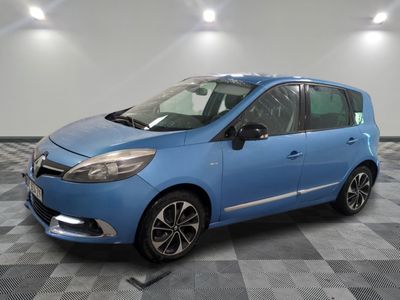 une voiture bleue est garée dans une pièce au sol à carreaux