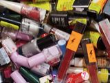 a pile of various colored lipsticks in a bin