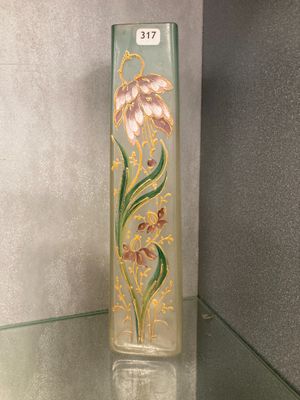 a glass vase with a flower on it on a glass shelf