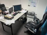 un bureau avec deux ordinateurs et une chaise à côté