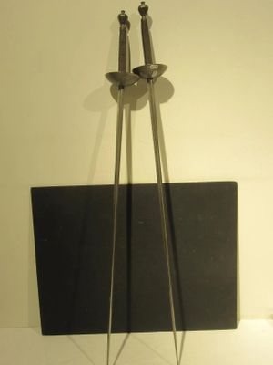 une sculpture métallique représentant une paire de ciseaux posée sur une table