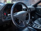 a steering wheel and dashboard of a car in a parking lot