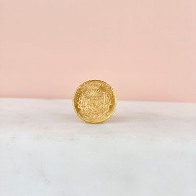 a gold coin sitting on top of a marble slab