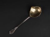 a silver spoon with a spoon handle sitting on a black surface
