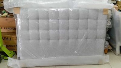 un matelas emballé dans du plastique et posé à même le sol
