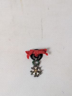 a picture of a small medal with a red ribbon around it