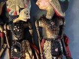 three wooden dolls of different sizes and colors on a shelf