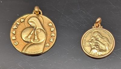 un gros plan sur deux pendentifs en forme de pièces d'or posés sur une table