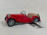 a red toy car that is sitting on a white surface