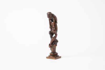 une vieille statue en bois représentant un homme tenant un oiseau, sur fond blanc