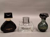 two bottles of perfume sitting next to each other on a white surface