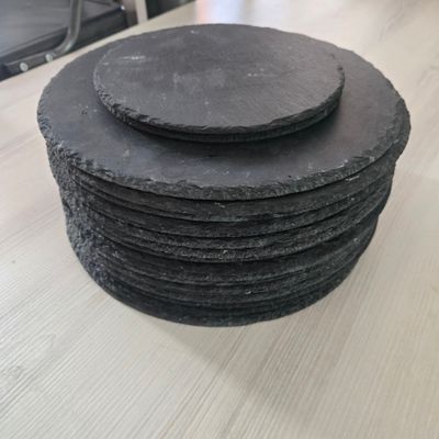 une pile de sous-verres en ardoise posée sur une table