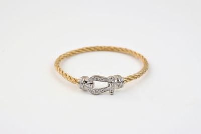 une bague en or jaune et or blanc, de forme torsadée, avec un fermoir serti d'un diamant