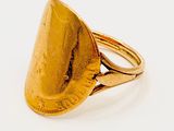 an image of a gold ring on a white surface