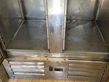 a stainless steel display case in the middle of a wooden floor