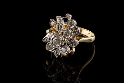 gros plan d'une bague en or et diamants sur une surface noire