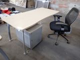 a desk with a chair and a computer on it
