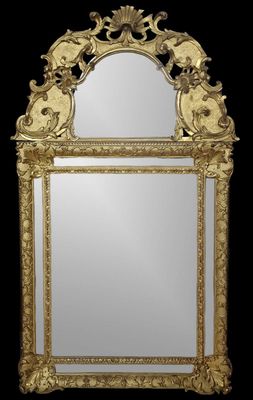 un miroir au cadre doré ouvragé sur fond noir