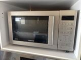 a microwave sitting on top of a shelf in a kitchen