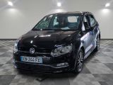 the black volkswagen polo is parked on a checkered tile floor