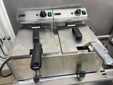 two deep fryers sitting on a table in a kitchen