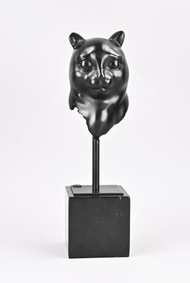 sculpture d'un chat sur un socle, sur fond blanc
