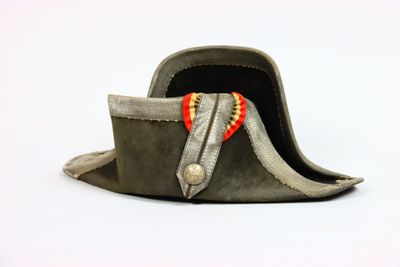 un vieux chapeau orné d'un ruban rouge et jaune sur le dessus