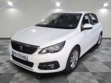 la voiture blanche est garée sur un sol en damier dans le garage