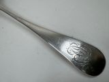 a spoon with a monogram on it sitting on a table
