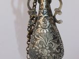 un vase en argent surmonté d'un oiseau