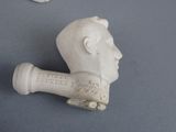 a statue of a man with a pipe sticking out of it ' s mouth