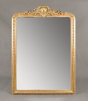 un grand miroir dans un cadre doré, orné d'un motif décoratif