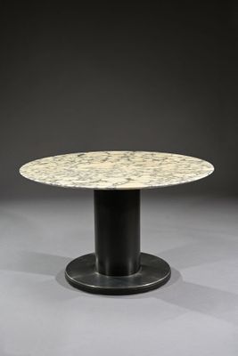 une table ronde en marbre avec un piètement noir et un piètement noir
