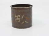 a brown cup with writing on it sitting on a white surface