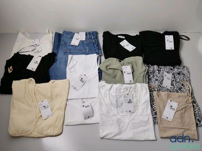 de nombreux types de chemises et de pantalons disposés sur une table