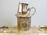 a silver plate with a silver cup on top of it