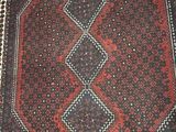 an old afghan rug with a red and black design