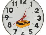 une horloge sur laquelle est posée une boîte de Kodak